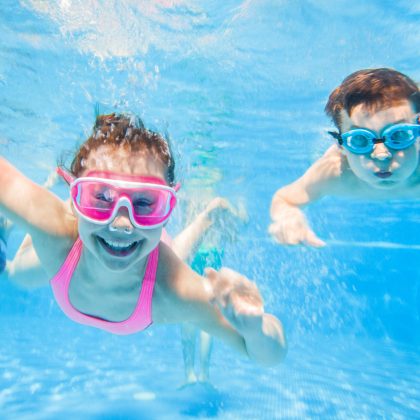 little children  playing and  swimming  in pool  under the water.